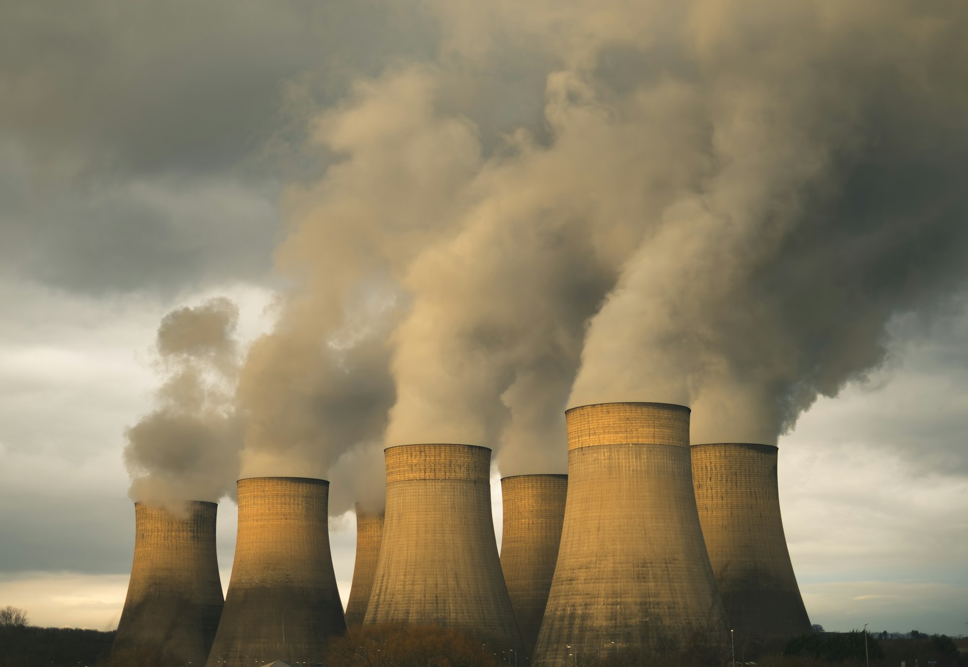 A group of smoke stacks emitting from a factory